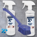 Dwa przezroczyste sprayowe butelki z profesjonalnym środkiem czyszczącym do granitu Z-Water X-Power na tle szarej powierzchni oraz niebieska szczotka do czyszczenia z długim uchwytem i gęstym włosiem umieszczona przed butelkami.